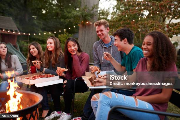 Adolescenti In Un Pozzo Del Fuoco Che Mangiano Pizze Da Asporto Da Vicino - Fotografie stock e altre immagini di Adolescente