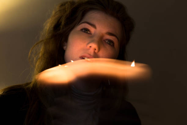 Young beautiful woman walking in the woods at night holding candle lantern.