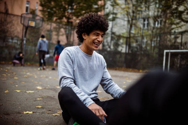 Cheerful player sitting on street during autumn