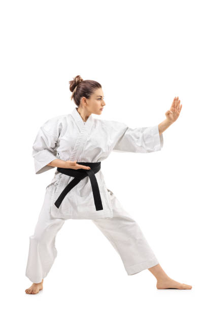 Karate girl doing a kata Full length profile shot of a karate girl doing a kata isolated on white background karate stock pictures, royalty-free photos & images