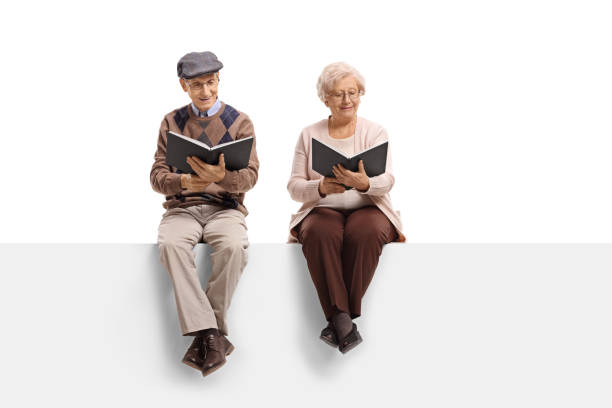 istock Seniors seated on a panel reading books 901578360