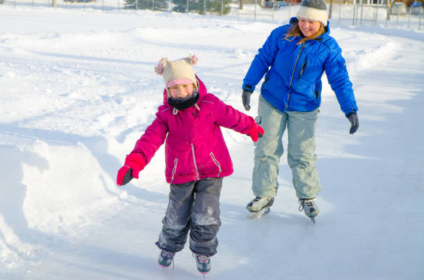 istock Mother teaching daughter how to ice skate 901580520