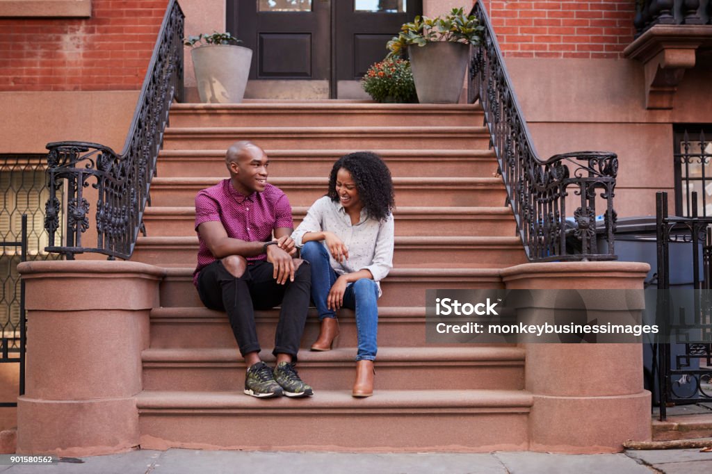 Paar sitzen und reden auf Stoop Brownstone In New York City - Lizenzfrei Sandsteinziegel Stock-Foto