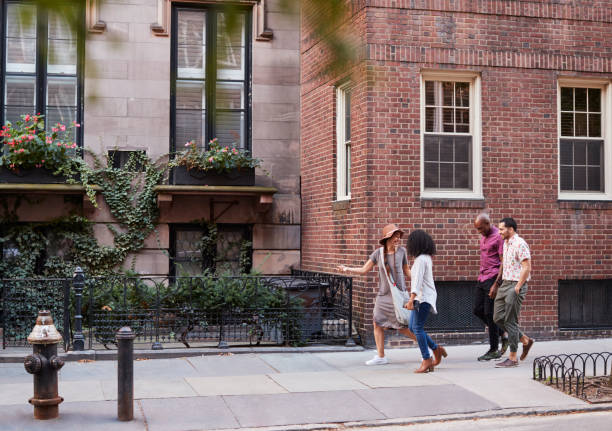 grupo de amigos caminando por la calle urbana en la ciudad de nueva york - piedra caliza de color rojizo fotografías e imágenes de stock