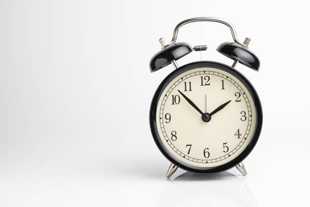 istock Retro black alarm clock on seamless white background with reflection using as time concept 901583256