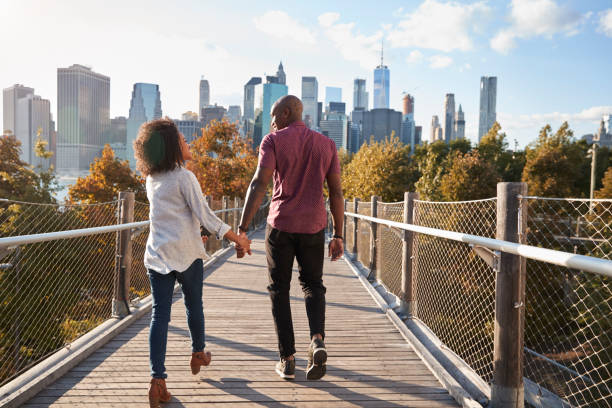 casal visitando nova iorque com o skyline de manhattan em fundo - rear view walking men people - fotografias e filmes do acervo