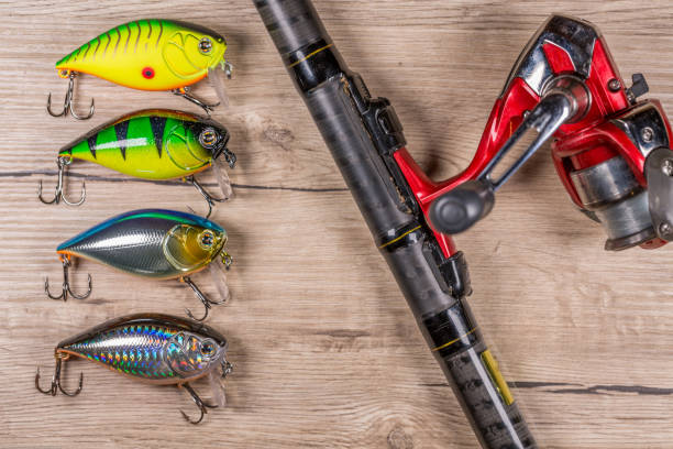 istock Fishing spinning and lures on wooden table 901587378