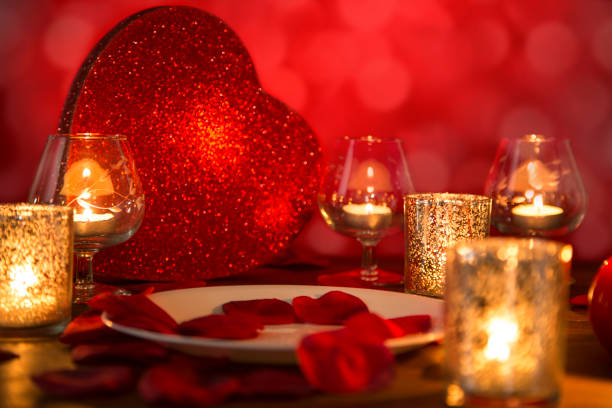 istock Valentine's Day romantic candlelight dinner with heart and rose petals. 901594540