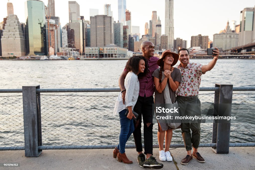 Grupo de amigos posando para Selfie na frente do horizonte de Manhattan - Foto de stock de New York City royalty-free
