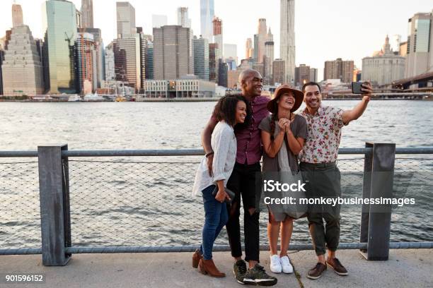 Foto de Grupo De Amigos Posando Para Selfie Na Frente Do Horizonte De Manhattan e mais fotos de stock de New York City