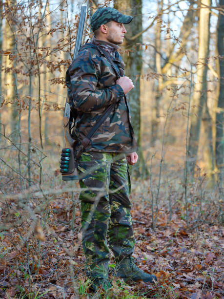 Hunter with shotgun Hunter in camo suit with double barrel shotgun double barrel gun stock pictures, royalty-free photos & images