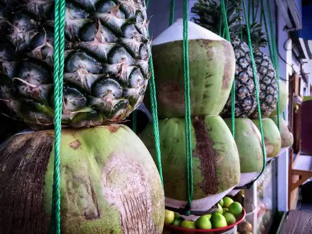Stacked Tropical Fruits Hanging in Front of Juice Store
