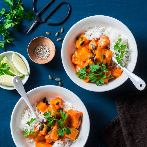 Buttery braised pumpkin and rice on blue background, top view. Vegetarian food concept