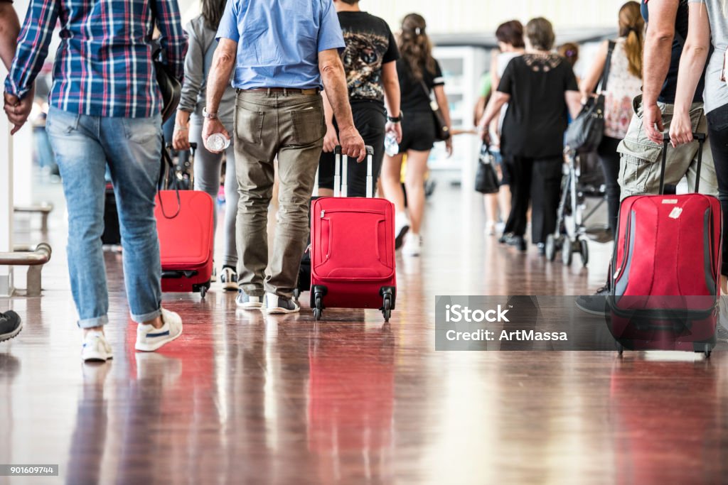 Travelers in Airport Travelers with suitcases walking through the airport Airport Stock Photo