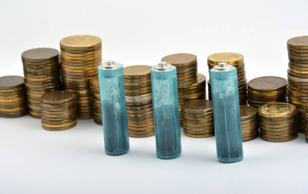 istock Three AAA batteries with coins isolated on white background 901617594