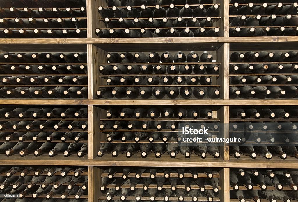 Rows of wine bottles stacked in a wine cellar Wine rack filled with bottles of vintage wine Port Wine Stock Photo