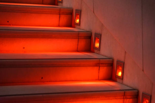 Abstract modern red stairs with warm light - stairway composition .