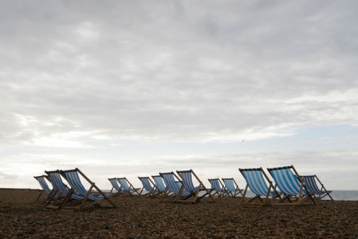A beach in the early morning full of empty deck chairs
