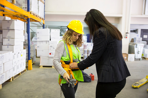 women with safety harness in warehouse.