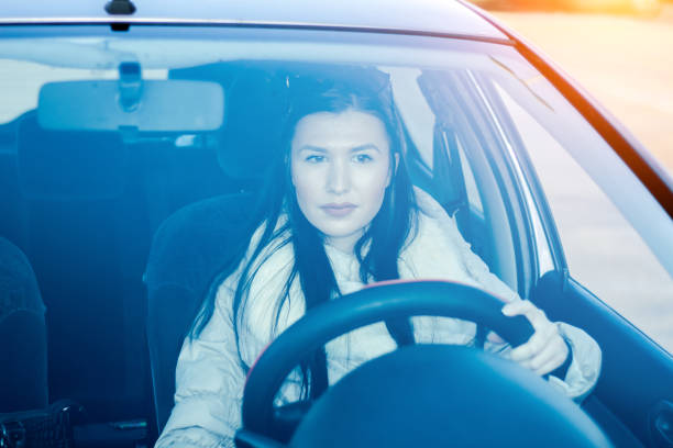 istock Young woman driving her car. 901630436