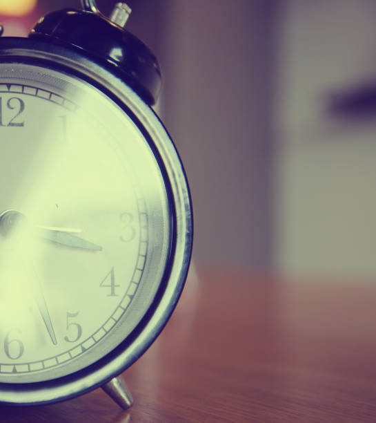 istock Retro alarm clock on a table. Photo in retro color image style 901642328