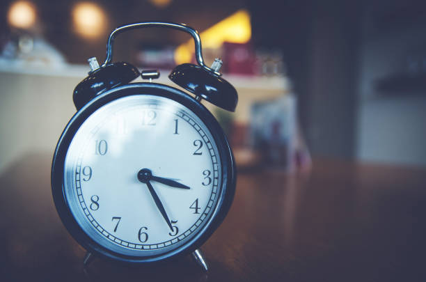 istock Retro alarm clock  on wood table 901644440