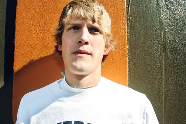 istock Young Blonde Guy Against Orange and Brown Wall 90164759