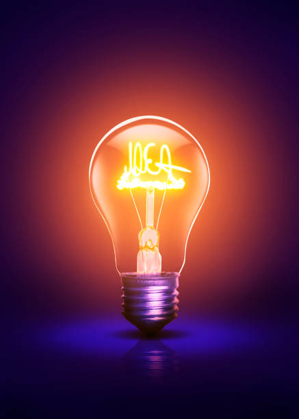 Idea written warm colored and active bulb on a dark purple background.