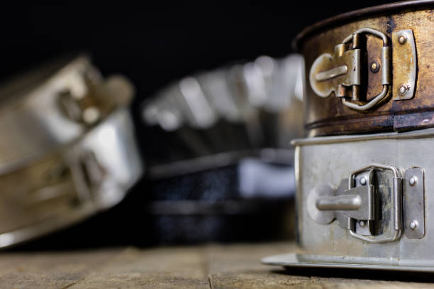 istock Tins and baking forms on a wooden table. Old kitchen accessories on the kitchen table. black background. 901651136