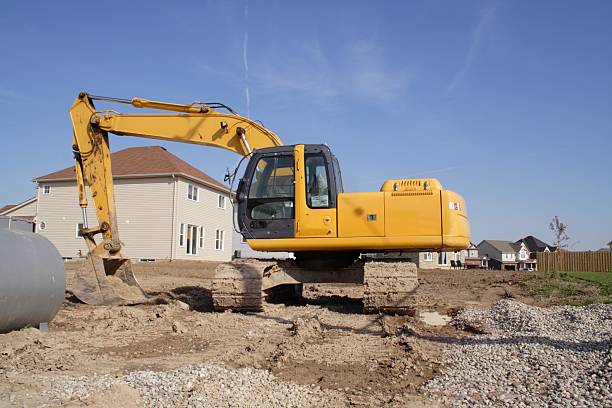 Excavator Waiting to Break Ground in a New Subdivision stock photo