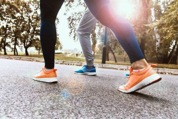 istock Unrecognizable couple running in nature. Legs View 901657156