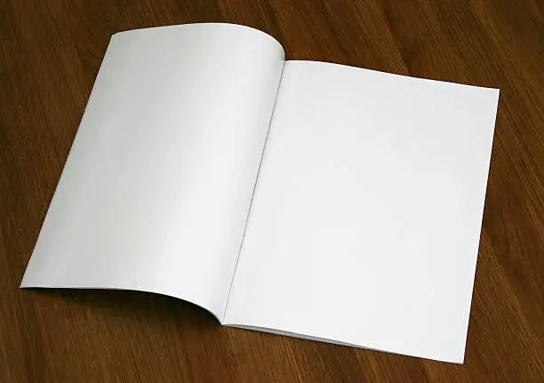 Photo of A blank magazine opened on a wooden surface