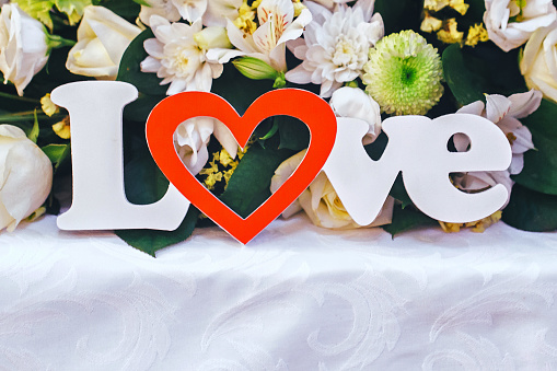 Wedding Inscription in Wooden Letters Love on Wedding Table with Flowers