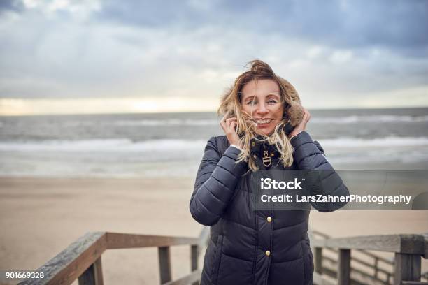 Frau Mittleren Alters Einen Kalten Wintertag Am Meer Trotzen Stockfoto und mehr Bilder von Winter