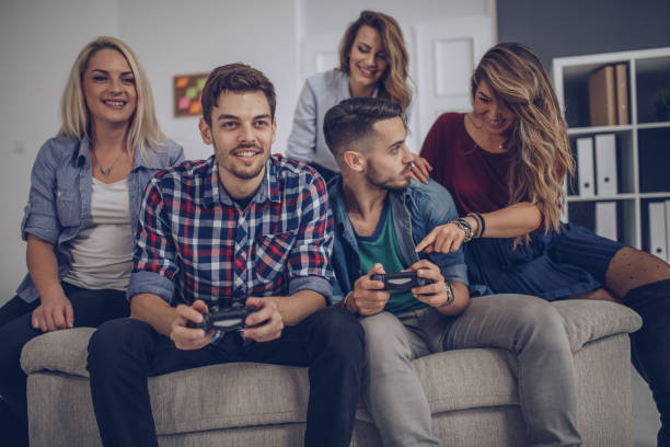 istock Young friends playing video games 901674292