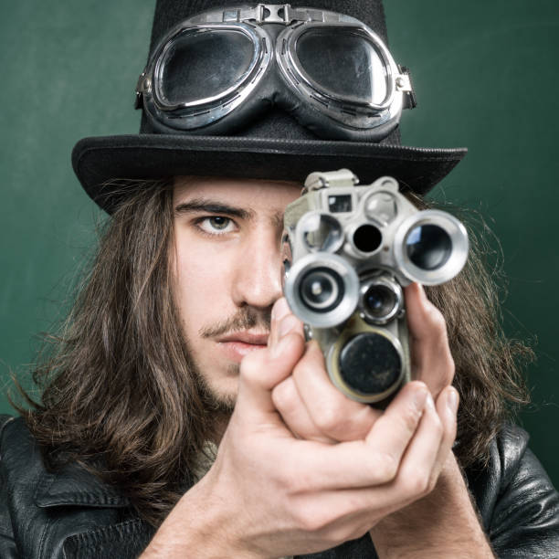 istock Young Man In Old Fashioned Style Filming Via Antique Camera 901675230