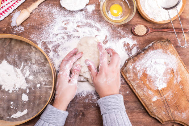 istock two female hands interfere with a ball of yeast dough 901684880