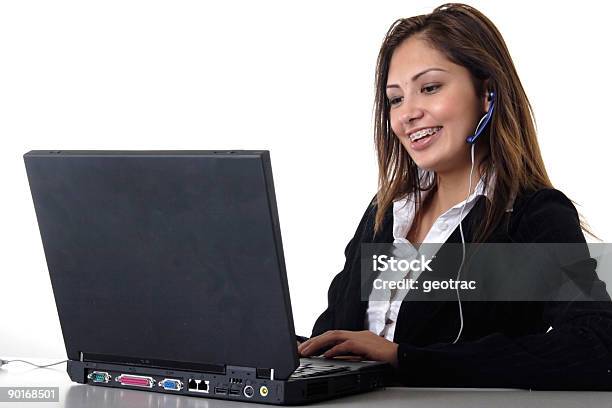 Foto de Feliz Jovem Recepcionista Usando Fone De Ouvido e mais fotos de stock de Vendedor de Loja - Vendedor de Loja, Administrador, Adulto