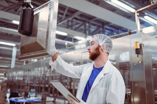 istock Factory Engineer With Hair Net Operating Machine With Digital Tablet 901693934