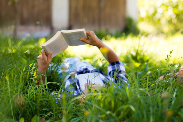 istock Girl reading a book on a meadow 901697316