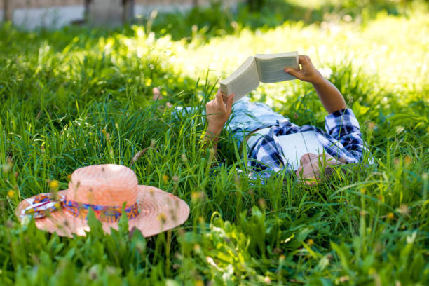 istock Girl reading a book on a meadow 901697322