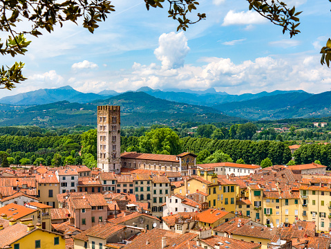 A view of the rooftops of the quaint Tuscan town of Lucca, Italy with mountain landscape in the background