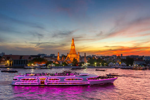 wat arun et bateau de croisière au crépuscule du temps, la ville de bangkok, thaïlande - arun photos et images de collection