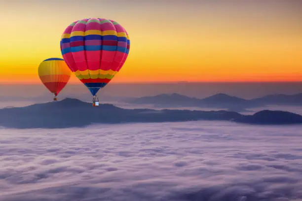 Aerial view from colorful hot air balloons flying over with the mist at Pha Tung mountain in sunrise time, Chiang Rai Province, Thailand