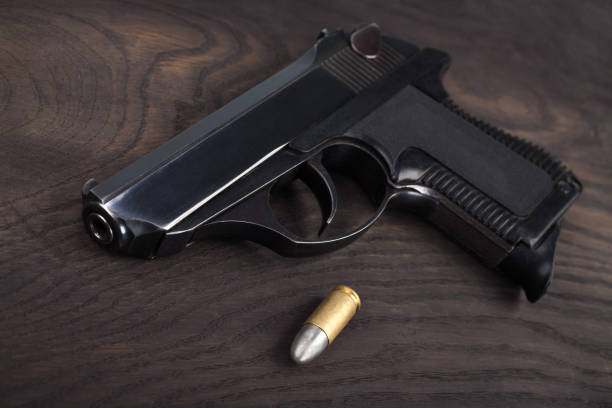 istock handgun with ammunition on the wooden table 901708822