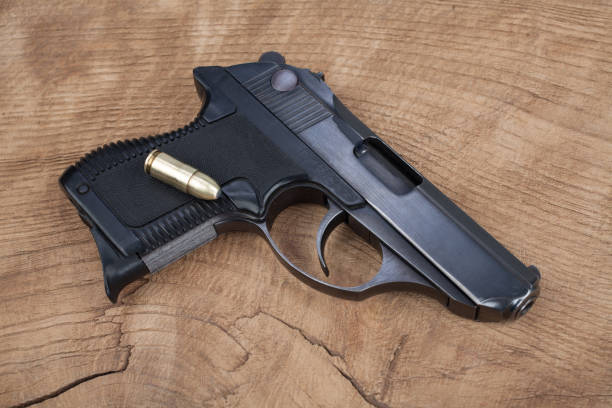 istock handgun with ammunition on the wooden table 901709030