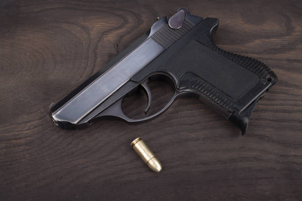 istock handgun with ammunition on the wooden table 901709172