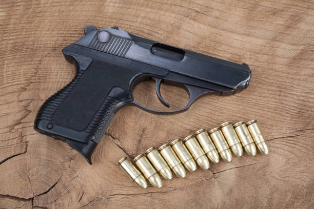 istock handgun with ammunition on the wooden table 901709324