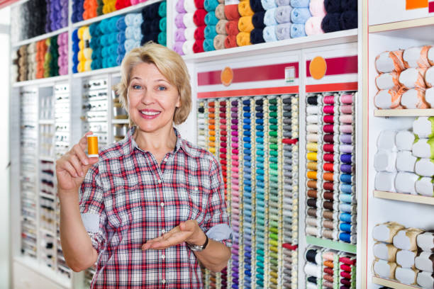 istock Female next to shelf with threads for sewing 901722558