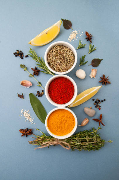Curry, rosemary, paprika and spicy herbs on a light blue pastel background. stock photo
